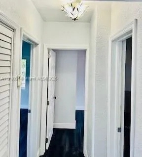 a view of a hallway with wooden floor and closet area