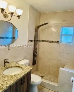 a bathroom with a granite countertop sink toilet and shower