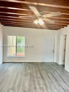 a view of a room with wooden floor and a window