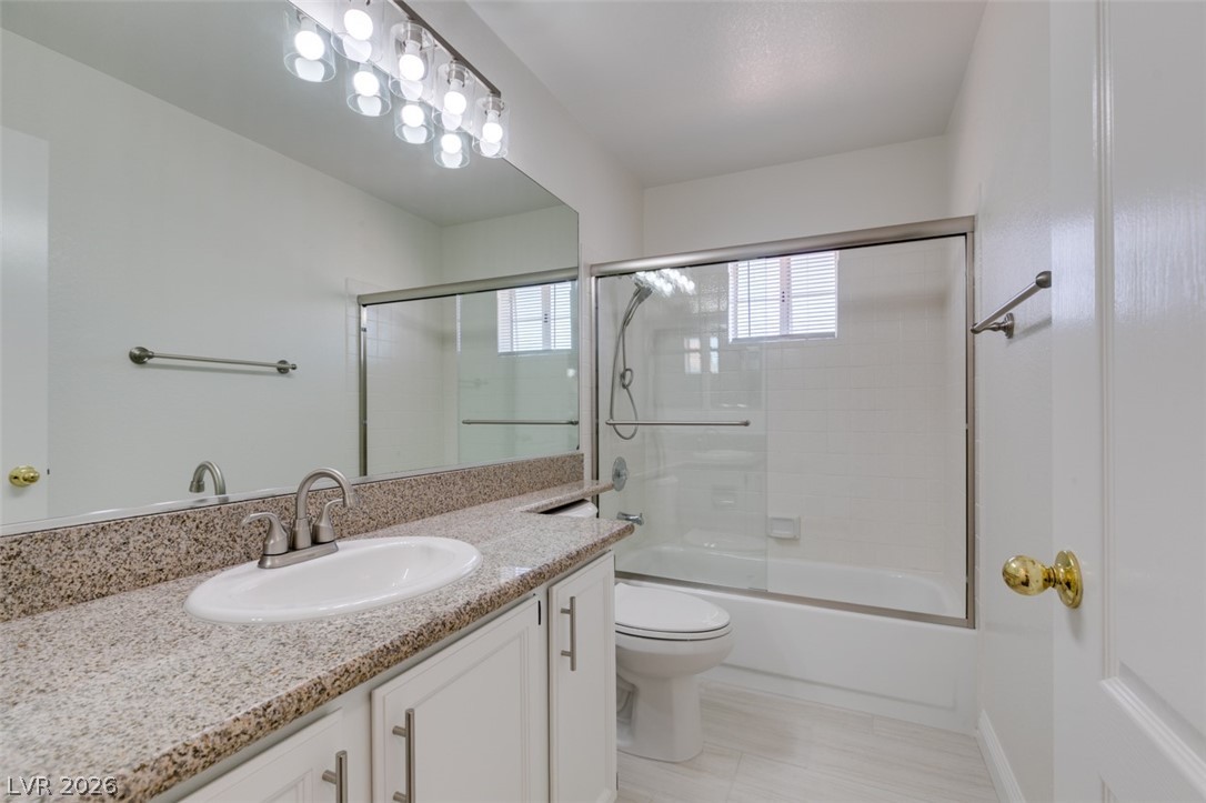 2113 Desert Peak Road Las Vegas, NV 89134 - Photo 25 of 33 This bathroom features a sleek vanity, an expansive mirror, and a convenient shower-tub combination.