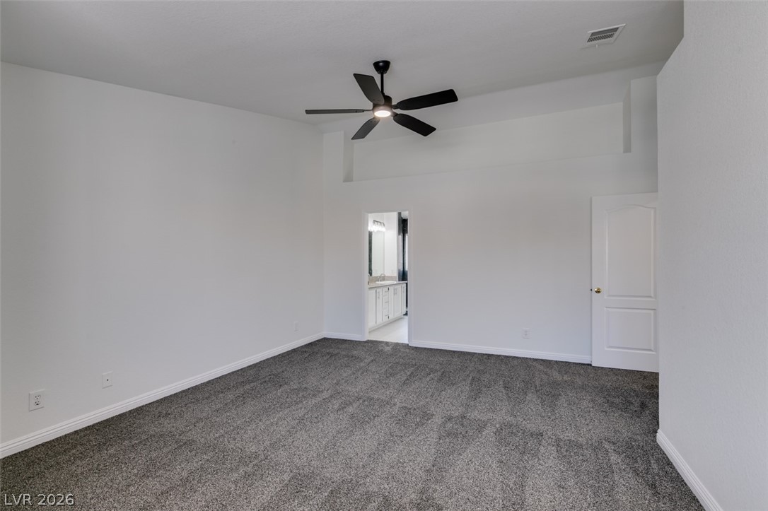 2113 Desert Peak Road Las Vegas, NV 89134 - Photo 29 of 33 This spacious primary bedroom features soft carpet and a cooling ceiling fan.