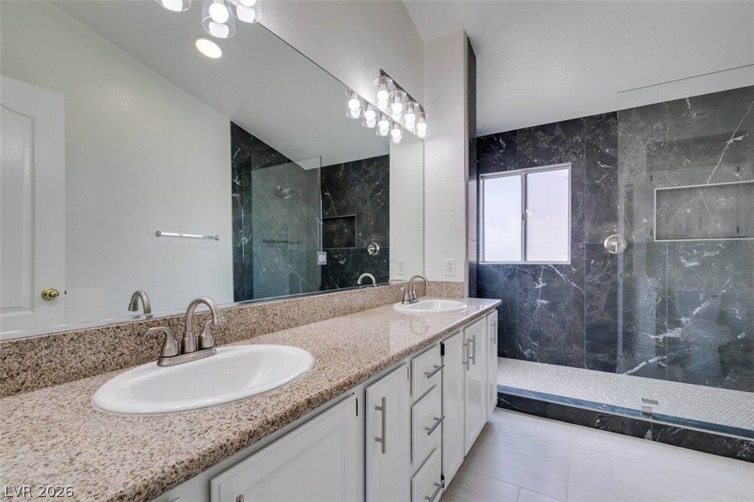 2113 Desert Peak Road Las Vegas, NV 89134 - Photo 30 of 33 This bathroom features dual vanities, a spacious shower, and elegant granite counters.