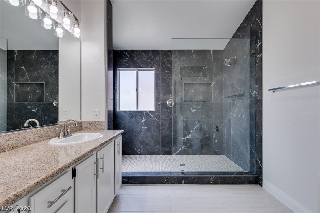 2113 Desert Peak Road Las Vegas, NV 89134 - Photo 31 of 33 This bathroom features elegant granite counters and a spacious walk-in shower with sleek glass enclosure.