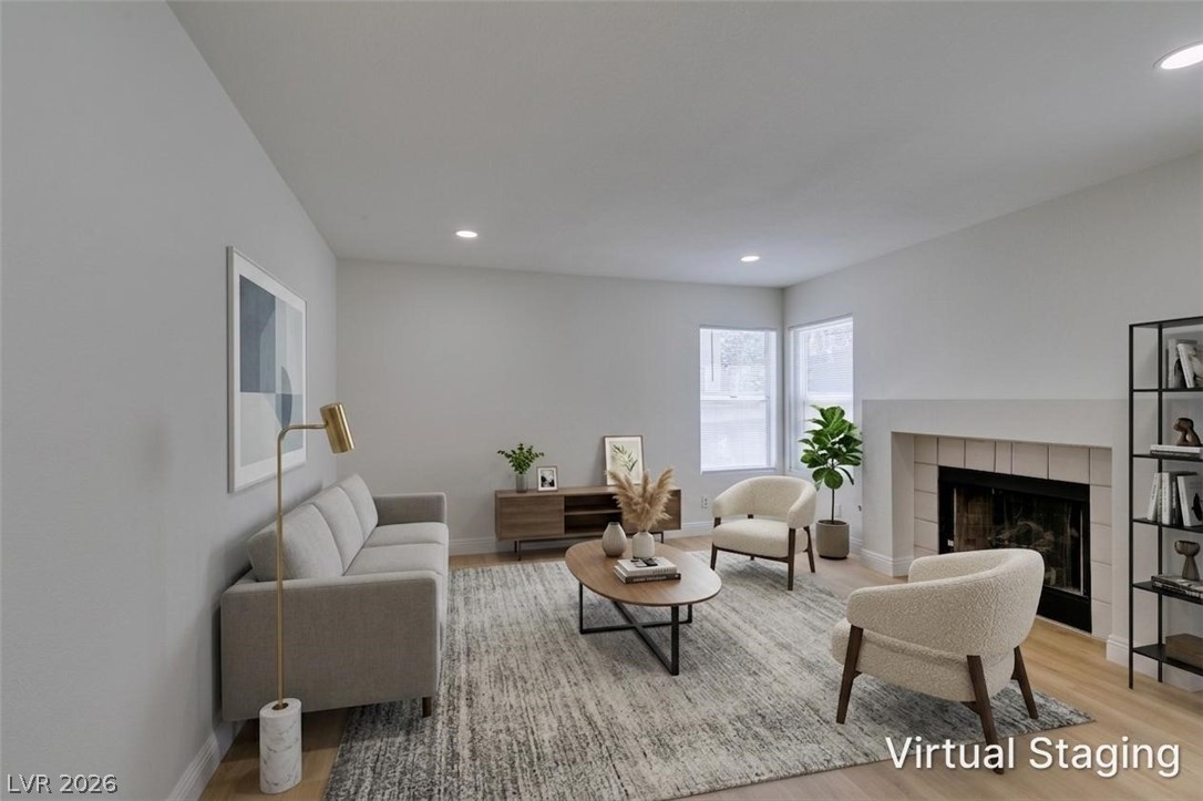 2113 Desert Peak Road Las Vegas, NV 89134 - Photo 10 of 33 This bright living space features light wood flooring and a cozy fireplace, creating an inviting atmosphere.