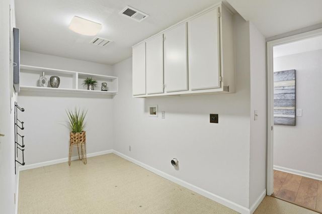 a front view of a house with a garden and trees
