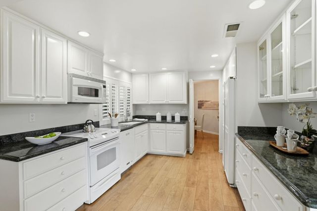 a kitchen with a table chairs sink and cabinets