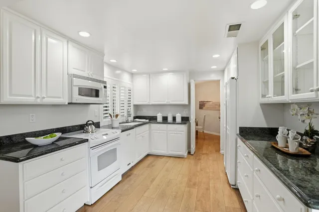 a kitchen with a table chairs sink and cabinets