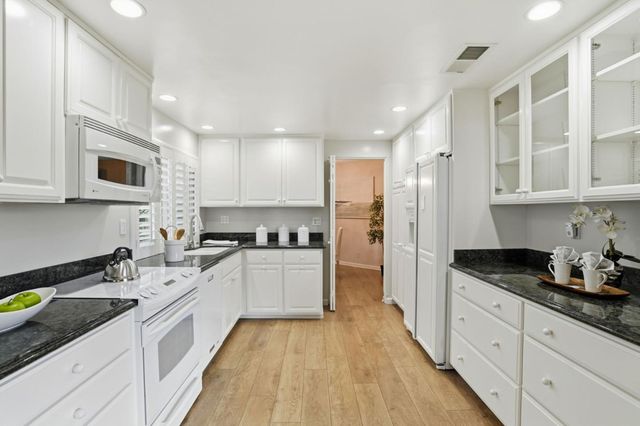 a view of a dining room and livingroom with furniture wooden floor and a chandelier