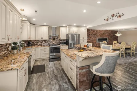 a kitchen with stainless steel appliances kitchen island granite countertop a stove and a refrigerator