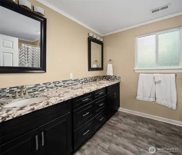 a bathroom with a granite countertop sink and a mirror