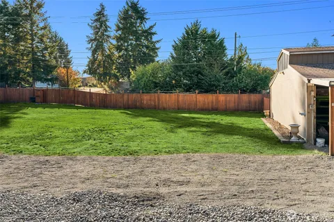 a view of a backyard with potted plants and wooden fence