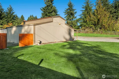 a view of a back yard of the house with green space and wooden fence