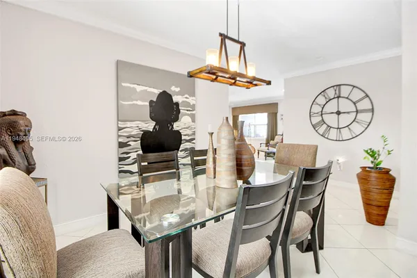 a dining room with chandelier and wooden floor
