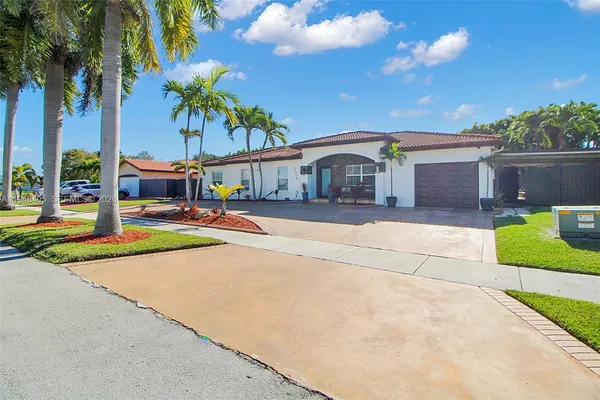 a front view of a house with palm trees