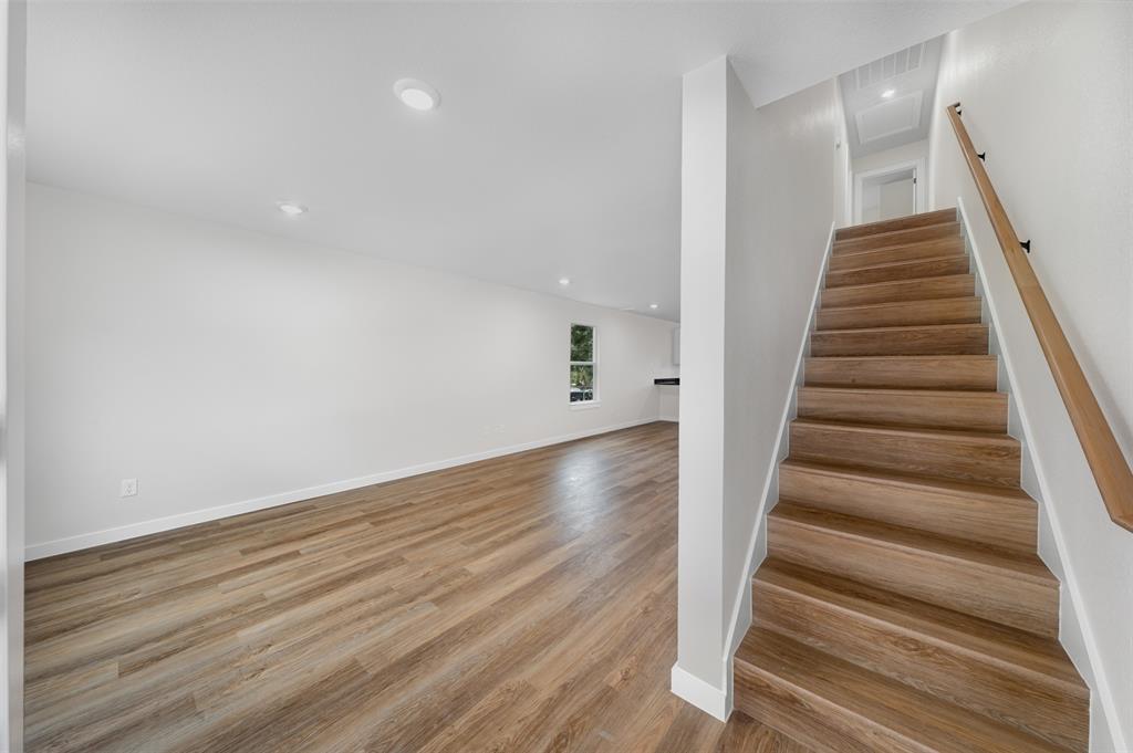 1536 Alexander Avenue, Unit A & B Waco, TX 76708 - Photo 19 of 30 The property features wood-look flooring throughout, recessed lighting, and a staircase with a wood handrail