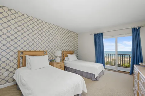 a bedroom with two beds and a lamp with window