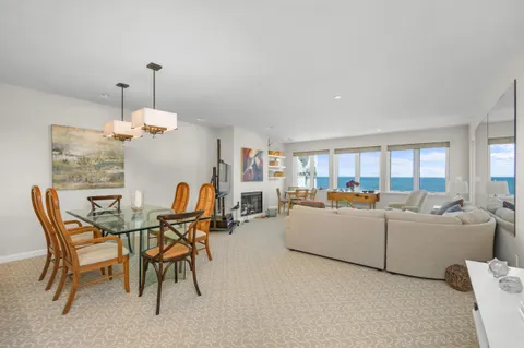 a living room with furniture kitchen view and a chandelier