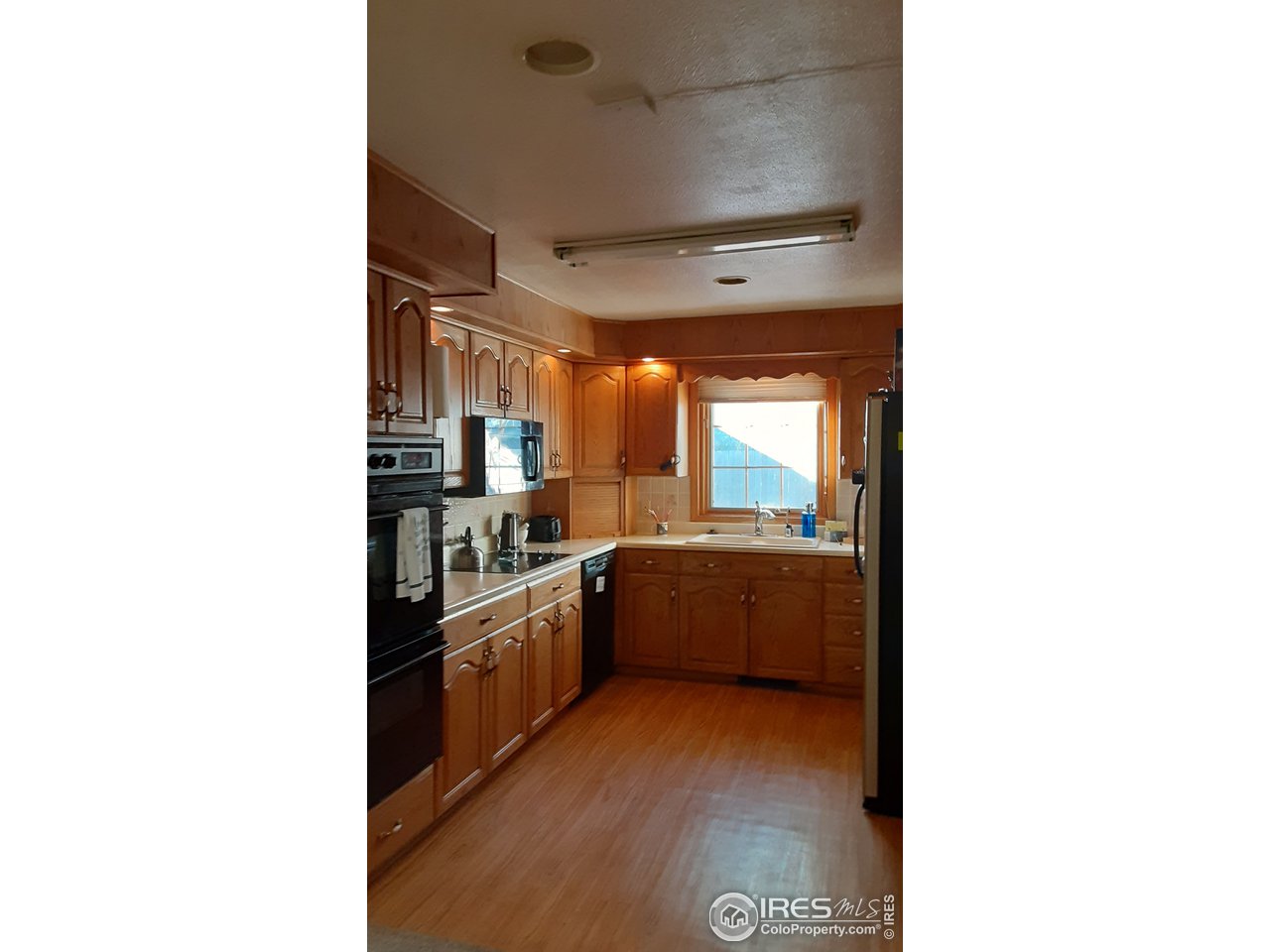 1401 Adams Circle Sterling, CO 80751 - Photo 3 of 16 a kitchen with stainless steel appliances kitchen island granite countertop a refrigerator and a sink