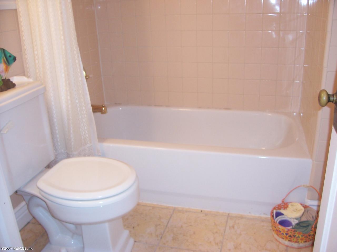 4908 Dundee Road Jacksonville, FL 32210 - Photo 10 of 16 a bathroom with a toilet and a bathtub