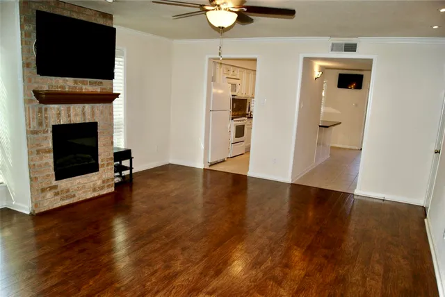 an empty room with a window and a fan