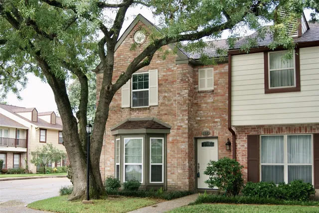 a front view of a house with yard and green space