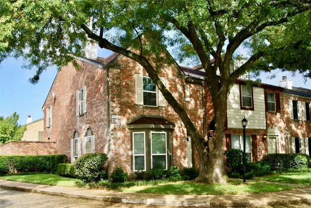 a front view of a residential houses with yard and green space