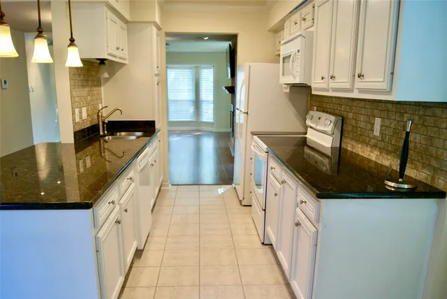 a kitchen with granite countertop a sink and cabinets