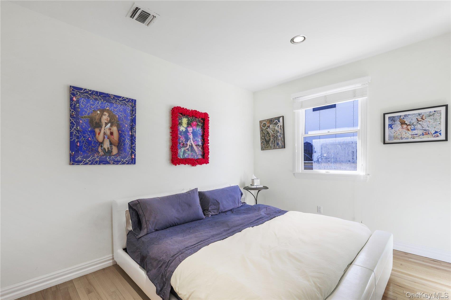 771 Dune Road West Hampton Dunes, NY 11978 - Photo 11 of 30 a bedroom with a bed and a wall painting