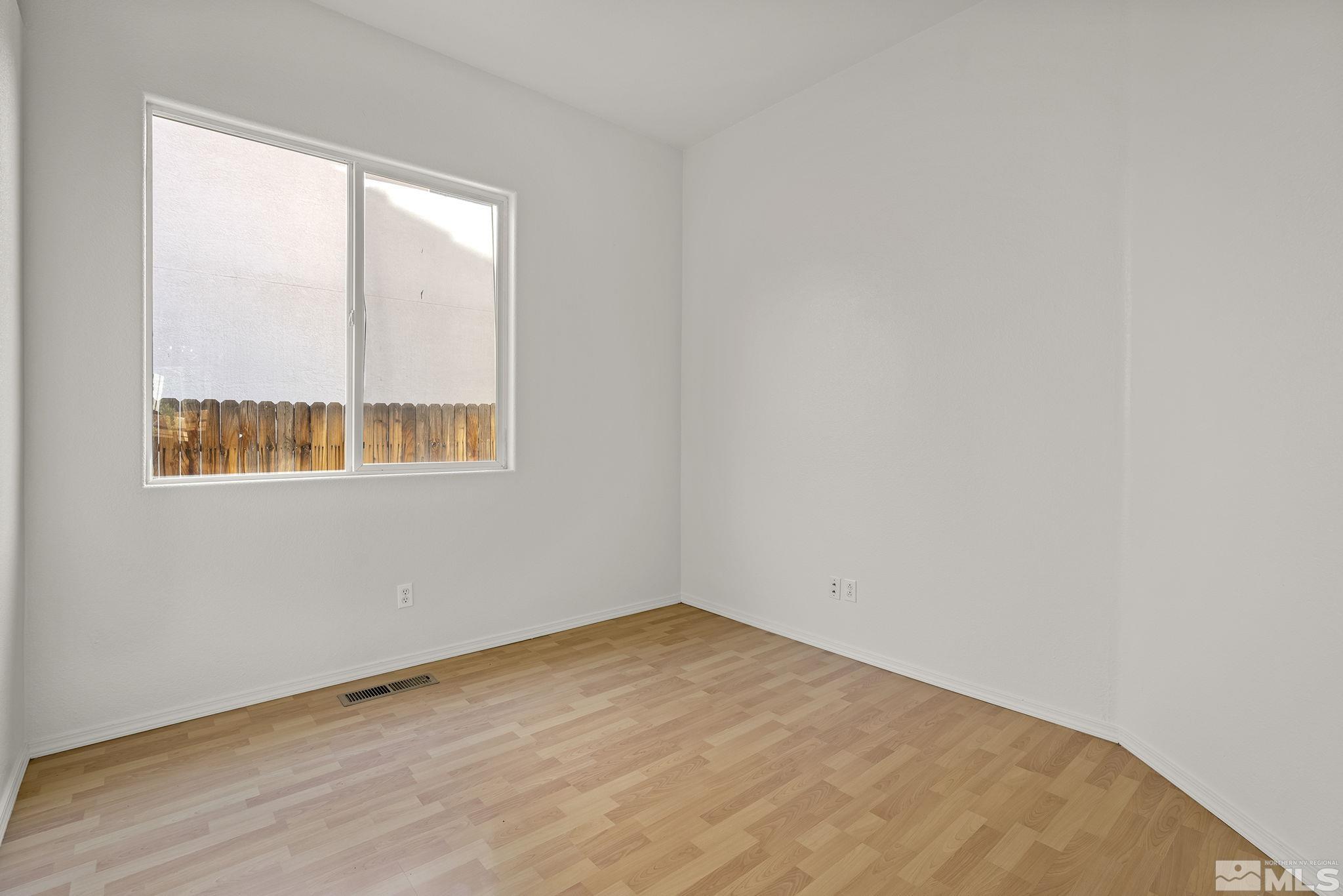 9671 Comanche Moon Drive Reno, NV 89521 - Photo 13 of 18 an empty room with wooden floor and windows