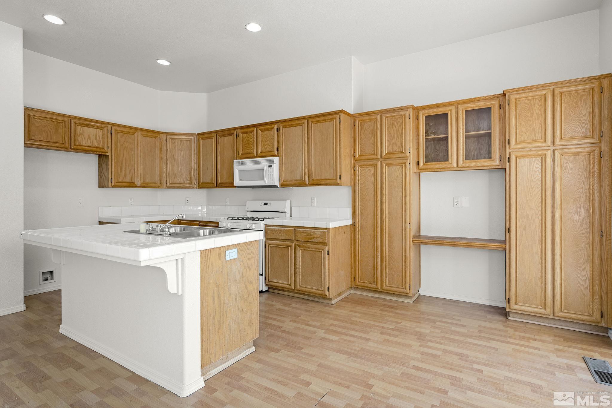 9671 Comanche Moon Drive Reno, NV 89521 - Photo 9 of 18 a kitchen with a stove a sink and a refrigerator