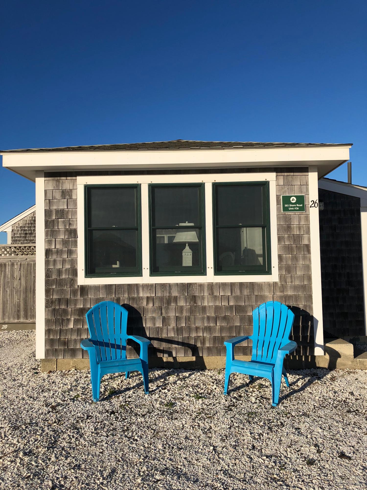 503 Shore Road, Unit 26 Truro, MA 02666 - Photo 16 of 17 a blue bench sitting in front of a house