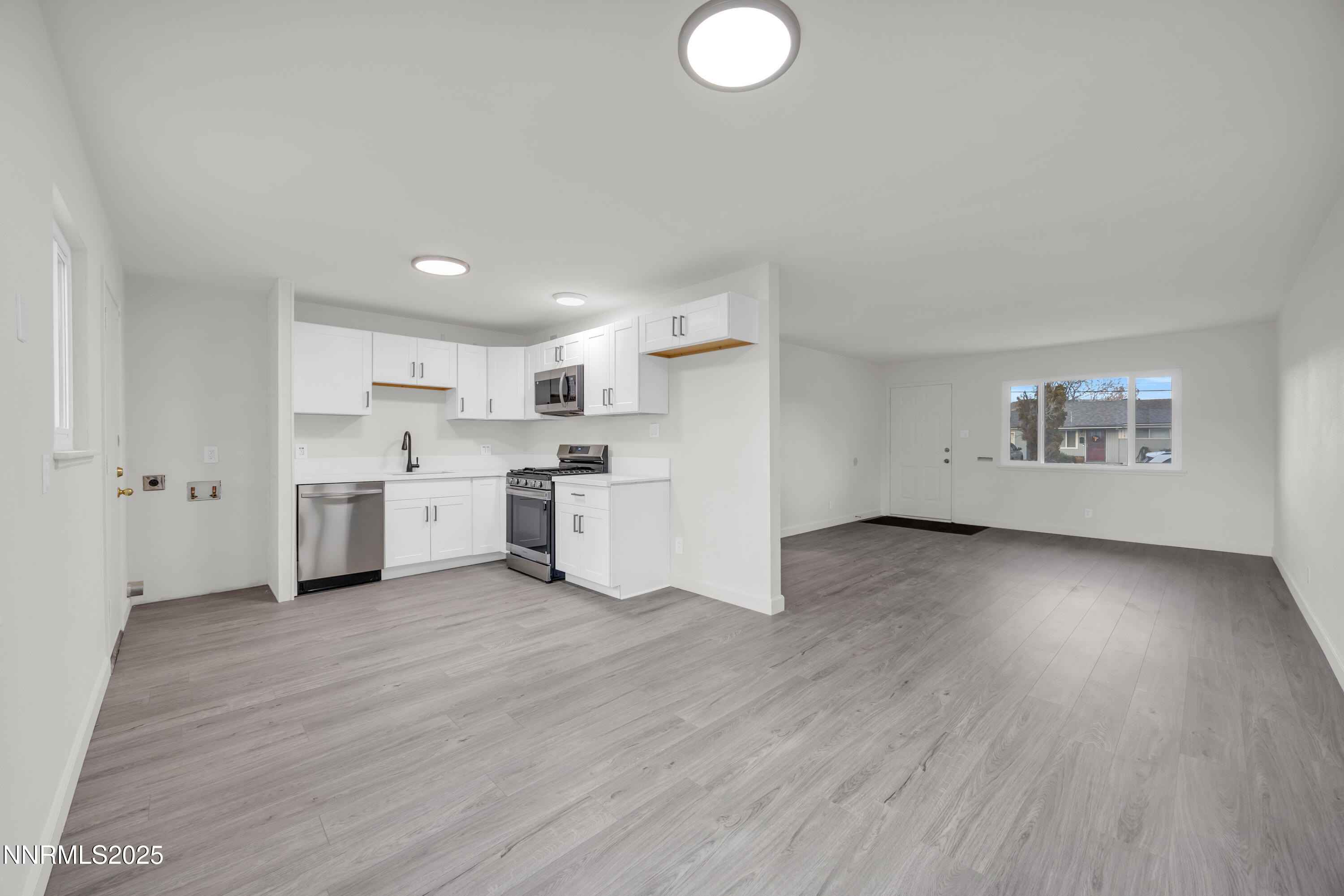 705 York Way Sparks, NV 89431 - Photo 3 of 17 a view of a kitchen with stainless steel appliances granite countertop a stove top oven a sink dishwasher and white cabinets with wooden floor