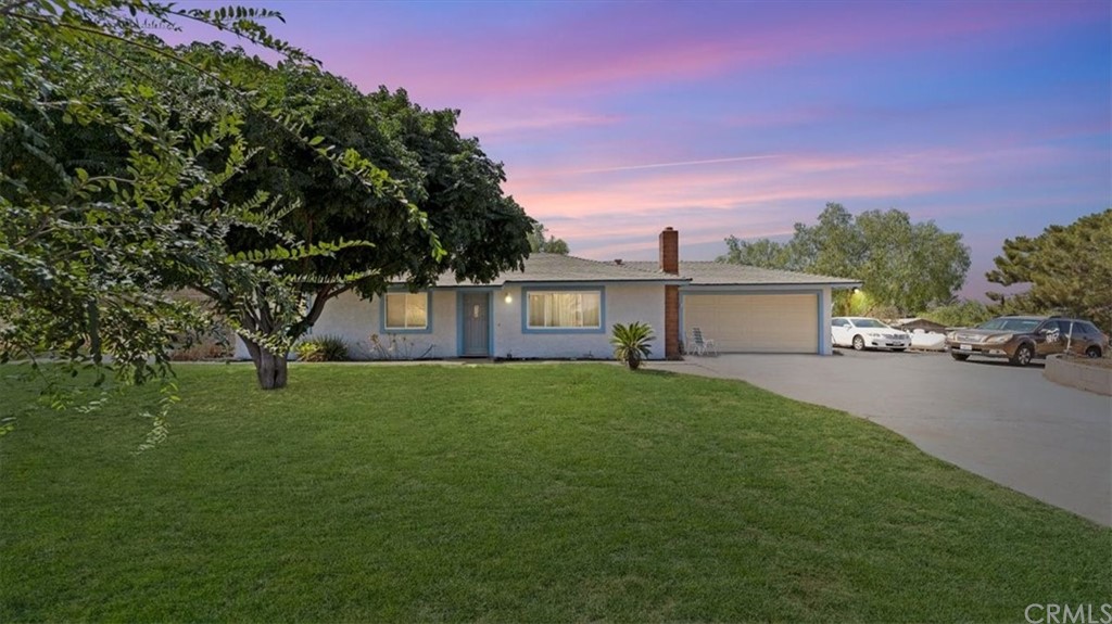 19261 Santa Rosa Mine Road Perris, CA 92570 - Photo 1 of 1 a front view of a house with a garden and trees