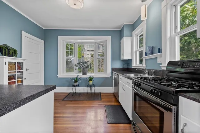 a kitchen with stainless steel appliances granite countertop a stove a sink and a granite counter tops with wooden floors