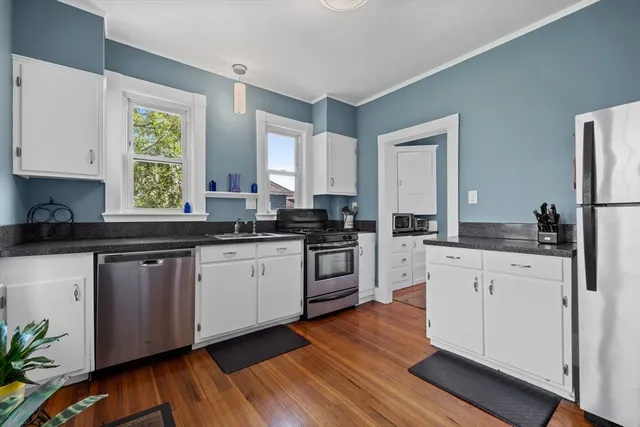 a kitchen with granite countertop white cabinets and white appliances