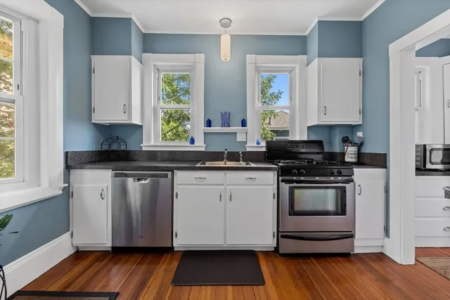 a kitchen with granite countertop a stove a sink and a microwave
