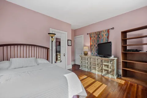 a bedroom with a bed and a flat screen tv