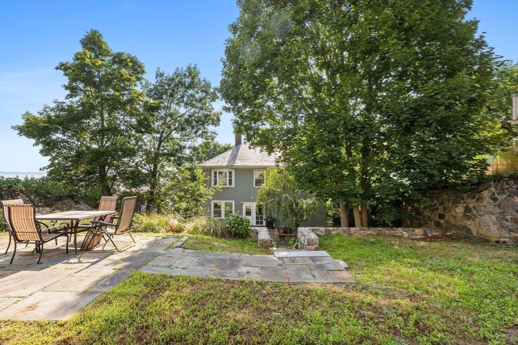 13 Cedar Hill Terrace, Unit 2 Swampscott, MA 01907 - Photo 28 of 34 a view of a patio with table and chairs and potted plants and large trees