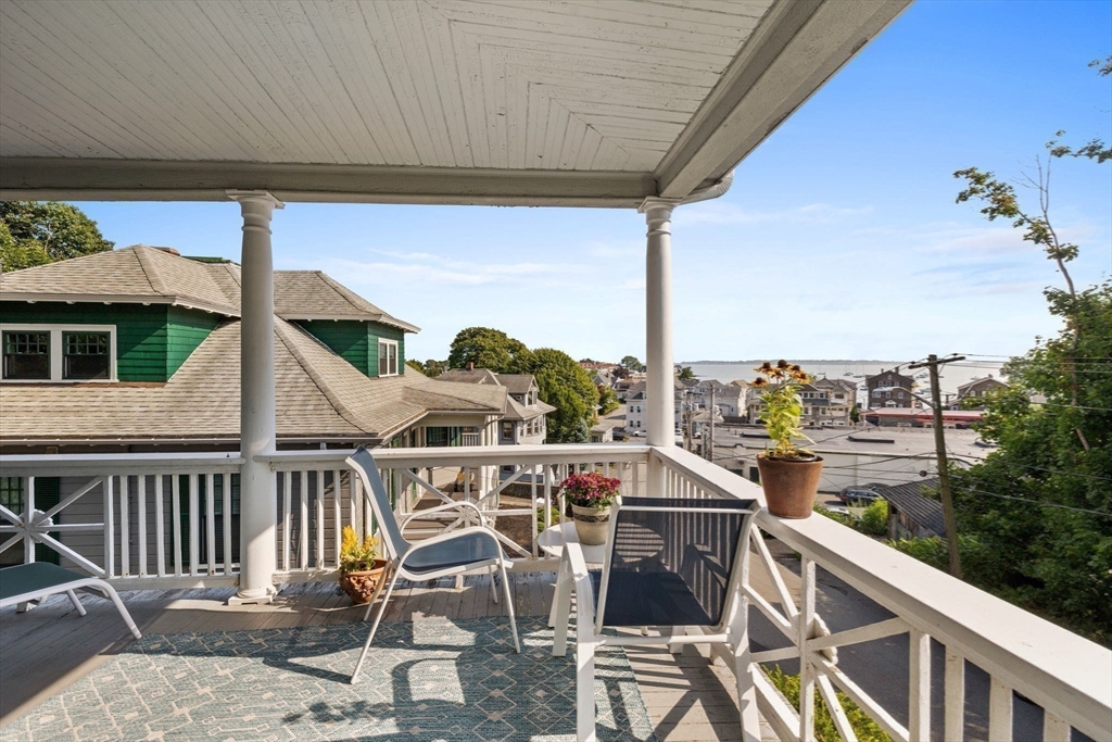 13 Cedar Hill Terrace, Unit 2 Swampscott, MA 01907 - Photo 31 of 34 a view of a patio with table and chairs with wooden floor and fence