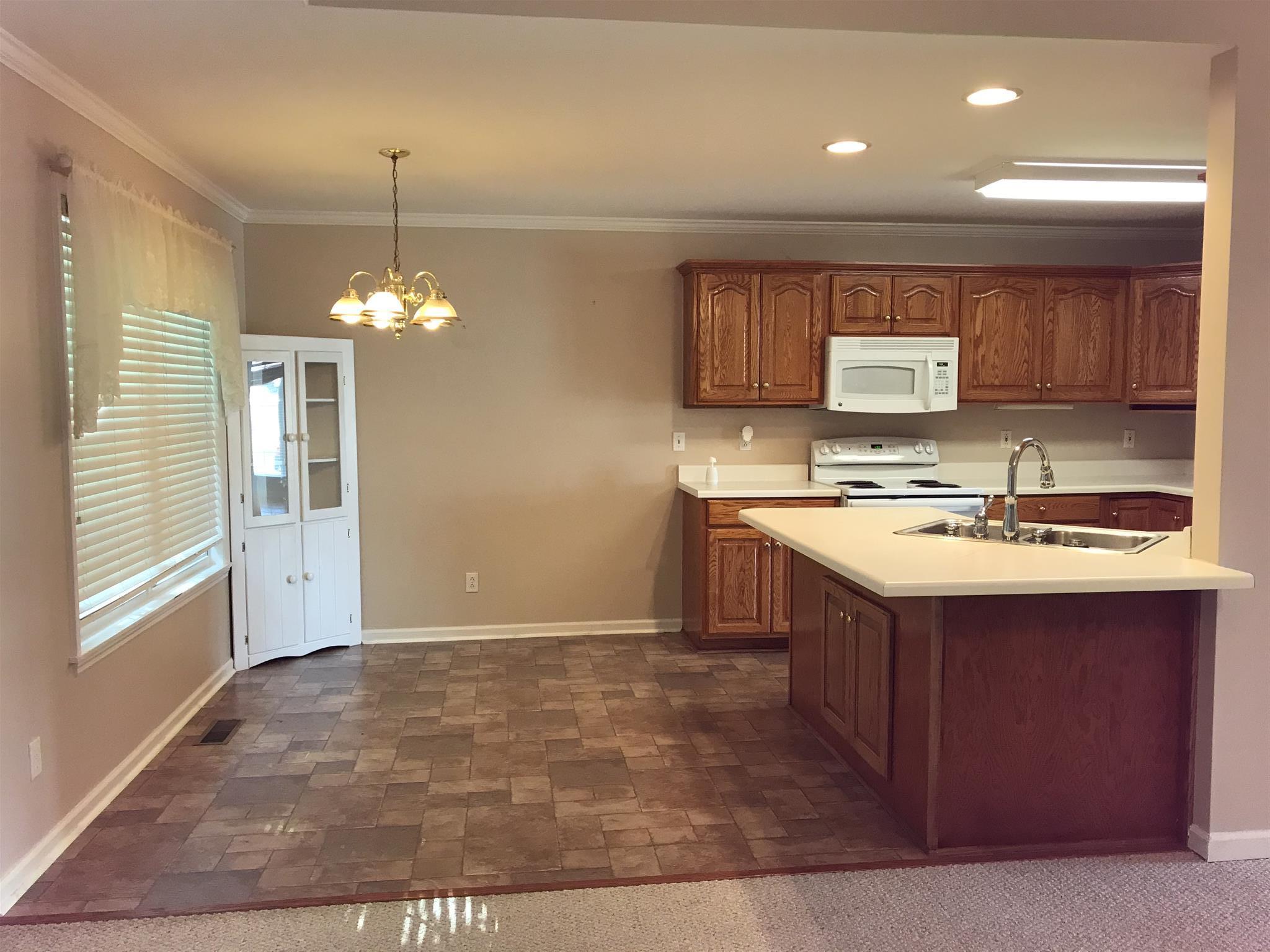 349 Duck River Road Manchester, TN 37355 - Photo 2 of 18 a kitchen with kitchen island granite countertop a sink cabinets and window