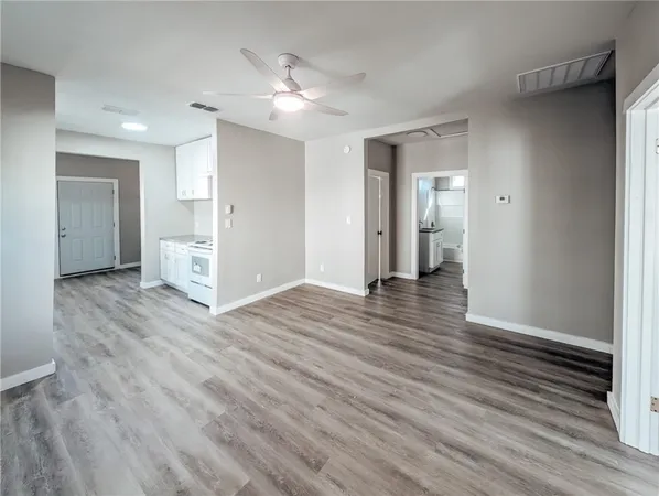 a view of an empty room with wooden floor