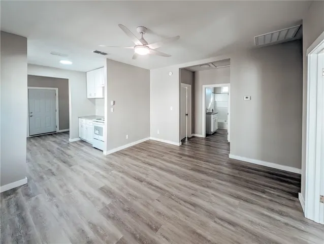 a view of an empty room with wooden floor