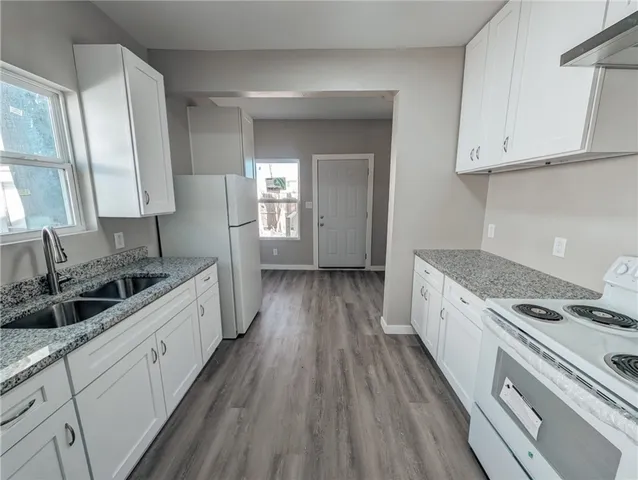 a kitchen with sink a stove and cabinets