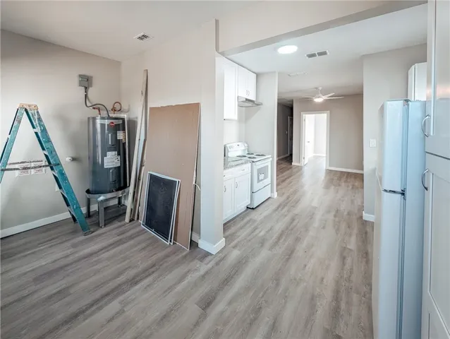 a view of a kitchen with refrigerator and wooden floor