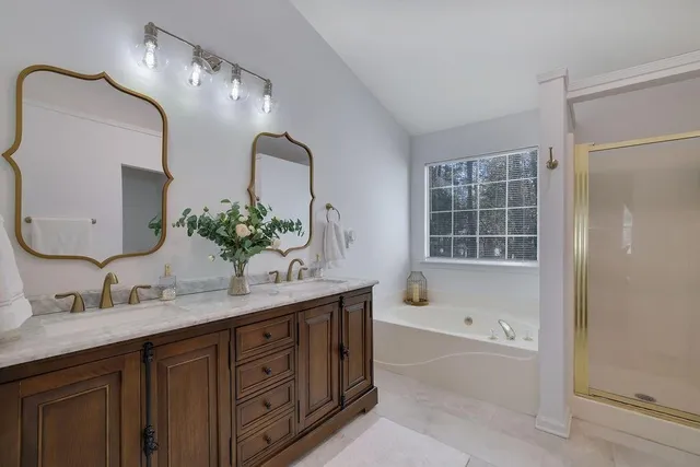 a bathroom with a tub sink and mirror