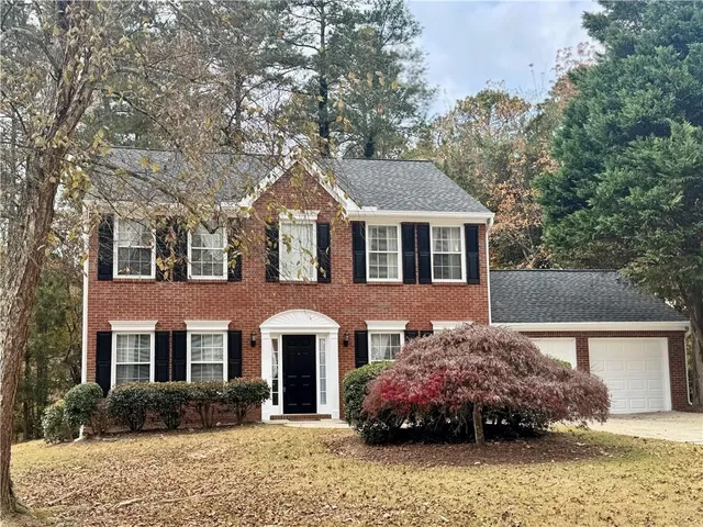 a front view of a house with a garden and plants
