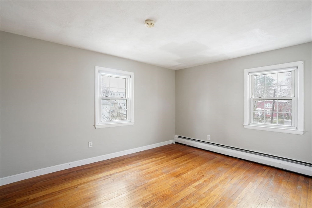 10-12 Norcross Circle Arlington, MA 02474 - Photo 12 of 31 a view of an empty room with wooden floor and a window