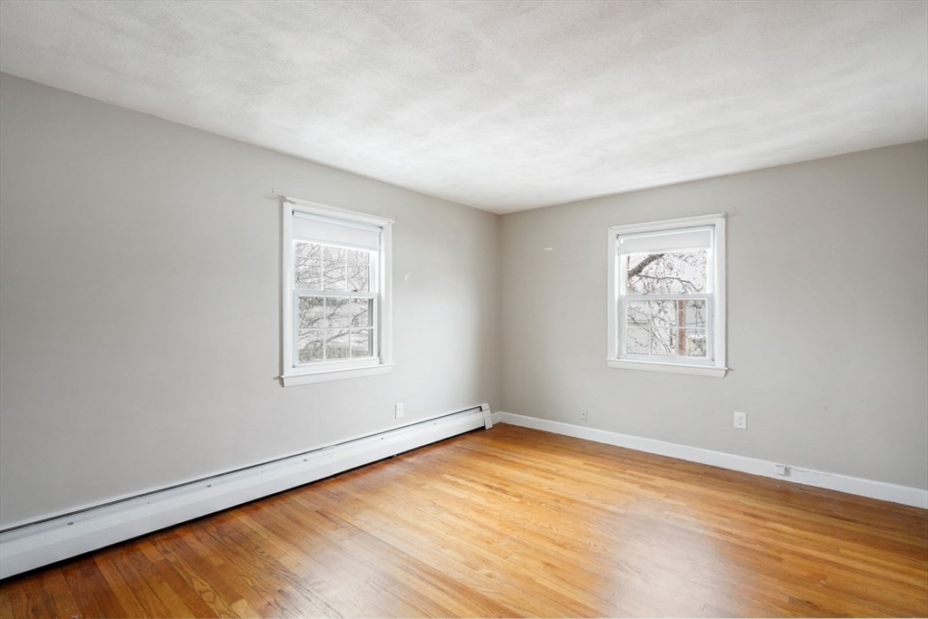 10-12 Norcross Circle Arlington, MA 02474 - Photo 15 of 31 a view of an empty room with wooden floor and a window