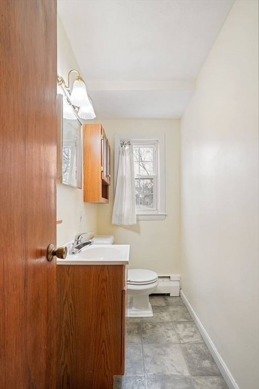 10-12 Norcross Circle Arlington, MA 02474 - Photo 19 of 31 a bathroom with a sink a toilet and a mirror