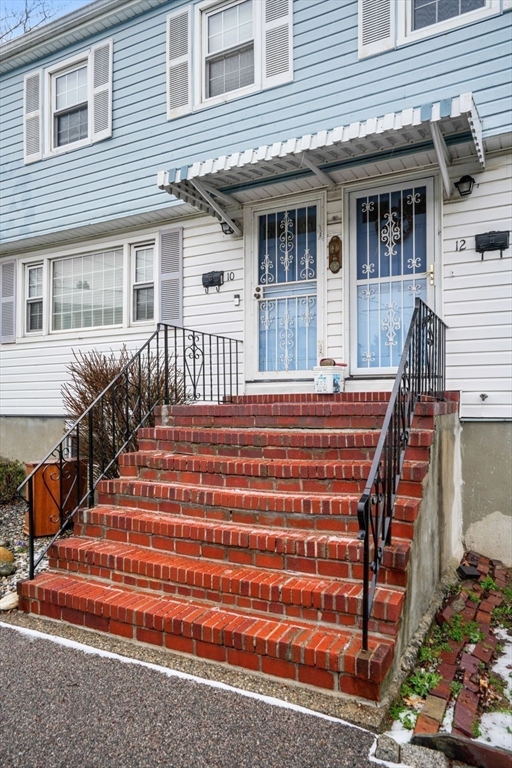 10-12 Norcross Circle Arlington, MA 02474 - Photo 2 of 31 a front view of a house with a porch